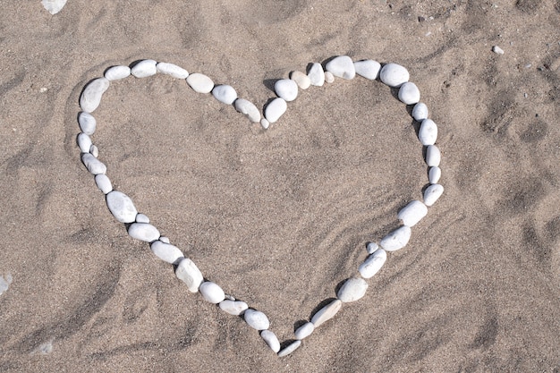 coeur fait de pierres sur une grotte au bord de la mer