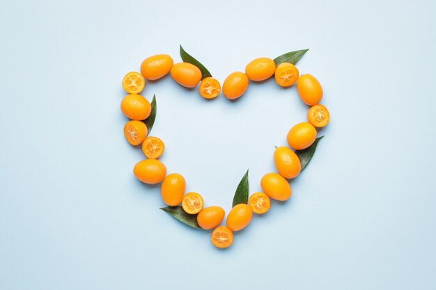 Coeur fait de savoureux fruits de kumquat sur la couleur