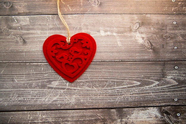coeur en feutre rouge sur un fond en bois. La Saint-Valentin