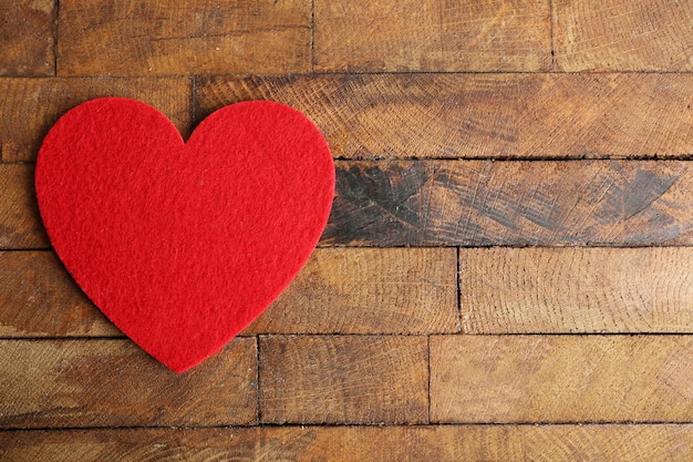 Coeur de feutre rouge sur fond de bois