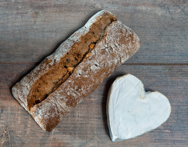 Photo coeur en forme de fromage de neufchâtel français sur la surface en bois