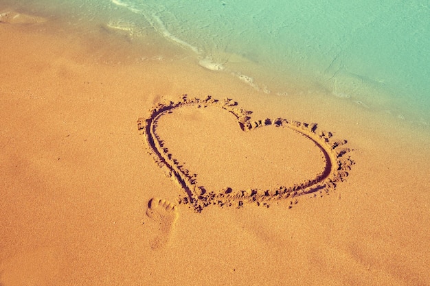 Coeur d'inscription sur le sable de la plage