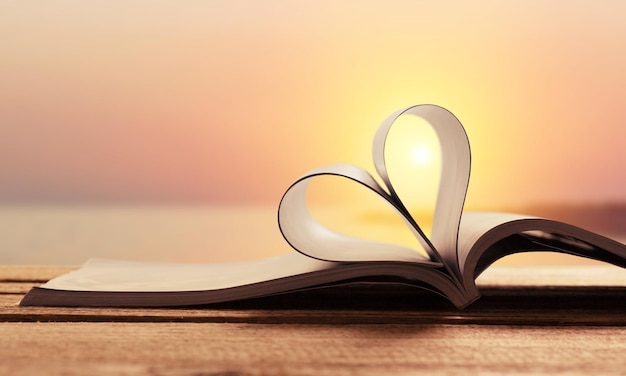 Coeur d'un livre sur fond de coucher de soleil