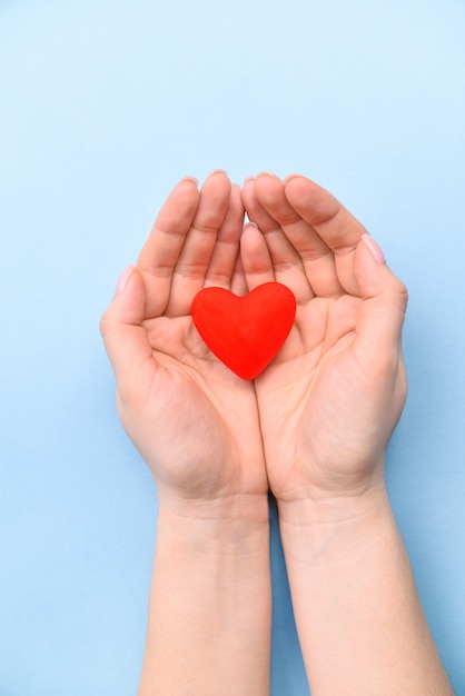 Coeur en mains sur fond bleu. Le concept de la Saint-Valentin et de la journée de la femme. Vue de dessus, place pour le texte. une vie