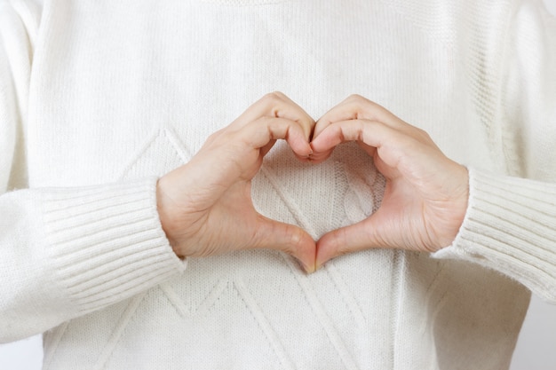 Coeur avec les mains. la jeune fille se tient la main dans la forme du coeur