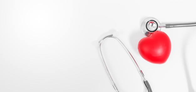Coeur médical rouge avec stéthoscope sur fond blanc.