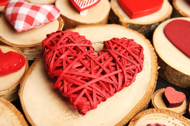 Coeur en osier rouge sur une bûche en bois se bouchent