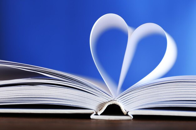 Coeur de pages de livre sur fond flou bleu