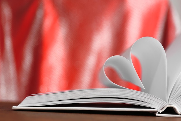 Coeur de pages de livre sur fond flou rouge