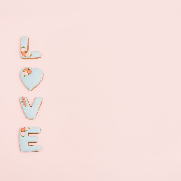 Coeur de pain d'épice, biscuits en forme de lettre d'amour avec glaçage sur rose pastel