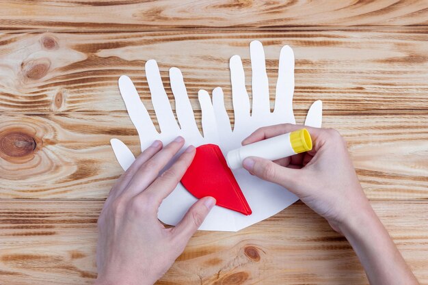 Coeur en papier artisanal dans les paumes pour la Saint-Valentin. Instructions pas à pas. Cadeau de bricolage.