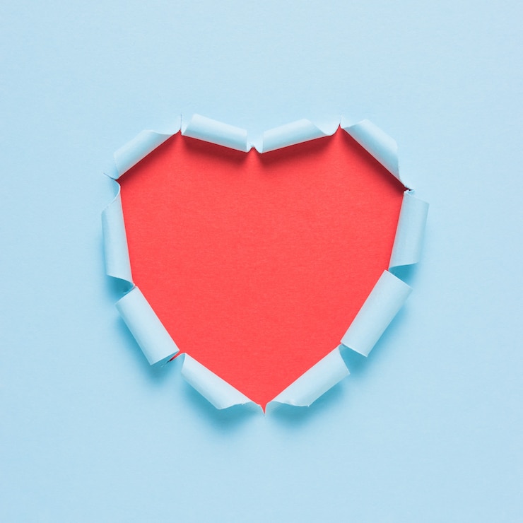 Photo coeur de papier déchiré vif sur fond clair.