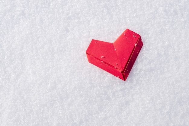 Coeur de papier rouge sur la neige blanche avec espace copie