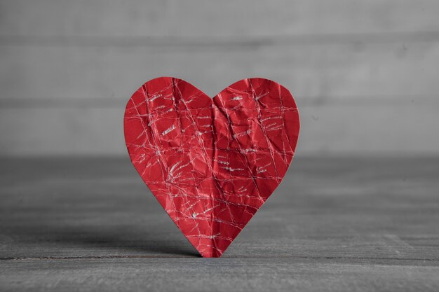 Coeur de papier rouge sur une surface en bois