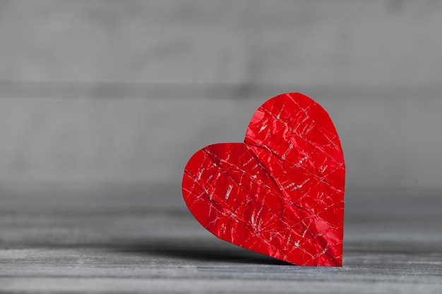 Coeur de papier rouge sur une surface en bois