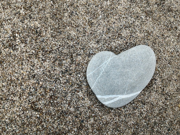 Coeur de pierre se trouve dans le sable Concept de l'amour