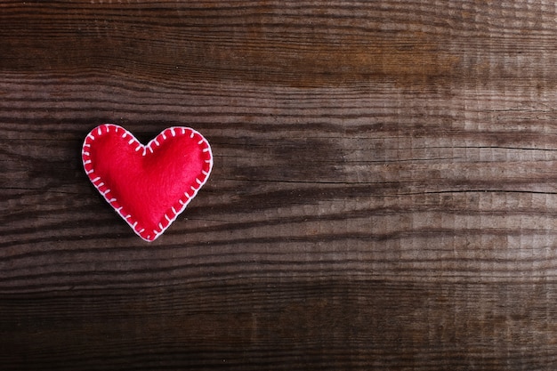 Coeur rose en feutre sur une table en bois