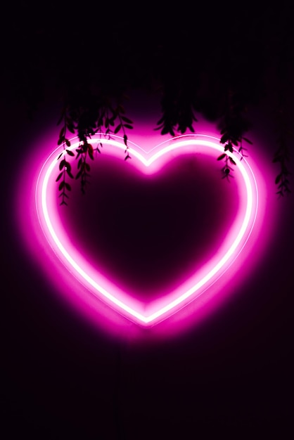 Coeur rose fluo sur mur noir