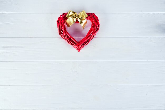 Coeur rouge en bois sur un fond en bois blanc. Fond de valentine