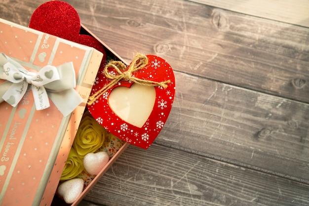 coeur rouge en bois avec place pour photo dans une boîte cadeau