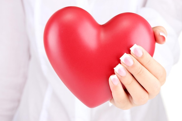 Coeur rouge dans la main de la femme, sur fond blanc close-up