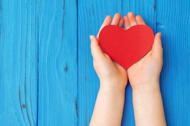 Coeur rouge dans les mains de l'enfant