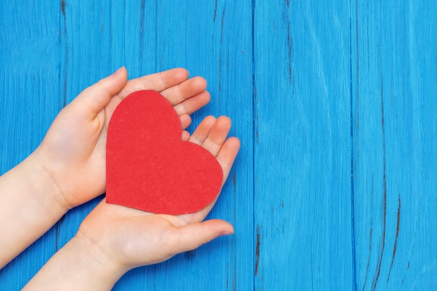 Coeur rouge dans les mains de l'enfant