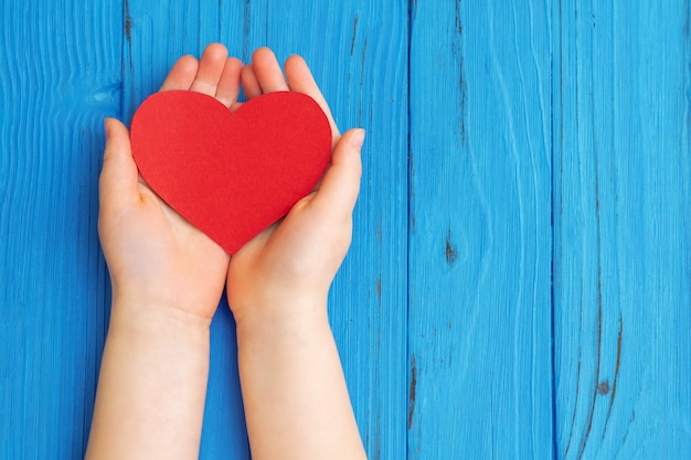 Coeur rouge dans les mains de l'enfant