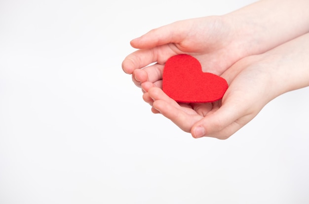 Coeur rouge dans les mains isolé sur fond blanc