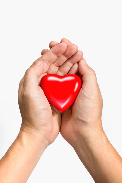 coeur rouge dans les mains isolé sur fond blanc