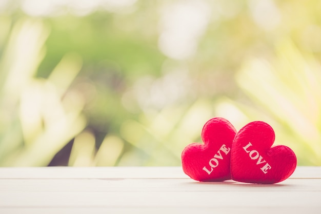 Coeur rouge sur le dessus de table en bois avec fond de flou nature bokeh