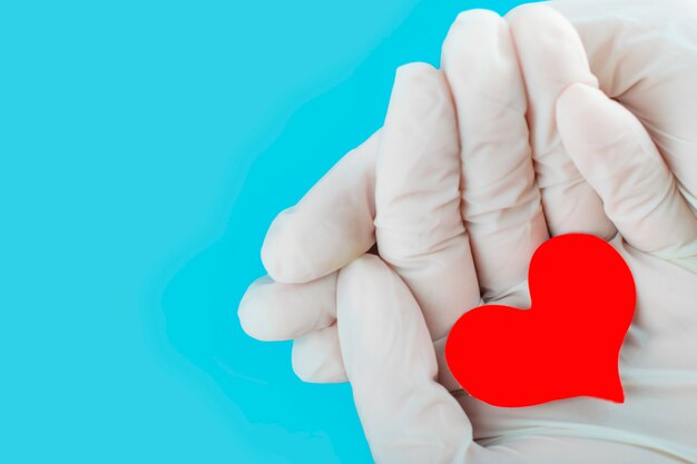 Coeur rouge entre les mains d'une infirmière. Journée mondiale du don de sang.