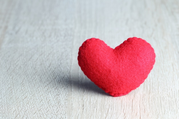 Le coeur rouge est placé sur un plancher en bois et dispose d’un espace de copie pour la conception.