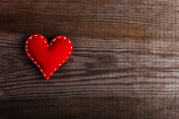 Coeur rouge en feutre sur une table en bois