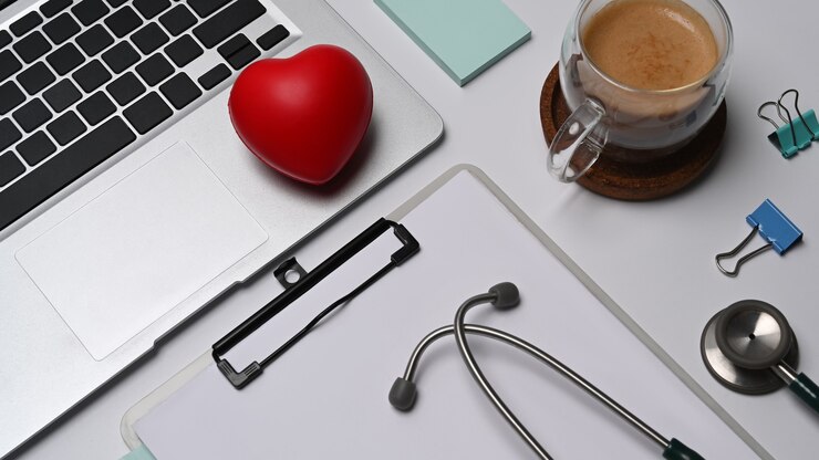 Photo coeur rouge, presse-papiers, ordinateur portable et stéthoscope sur fond blanc. concept d'assurance maladie.