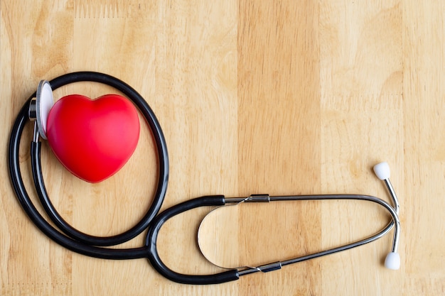 Coeur rouge et stéthoscope sur table en bois