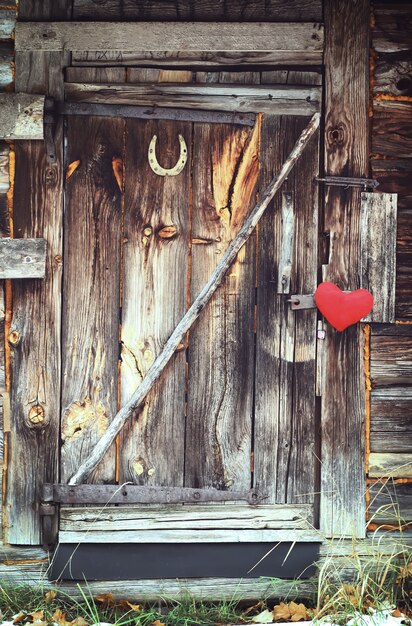 Coeur rouge sur la vieille porte en bois.