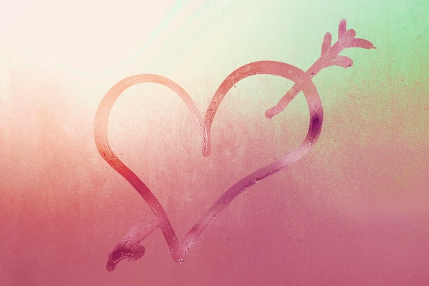 Coeur avec symbole de contour de flèche de l'amour sur fond rose dégradé de verre transparent embué