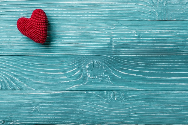 Cœur tricoté sur fond bleu en bois