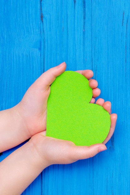 Coeur vert dans les mains de l'enfant