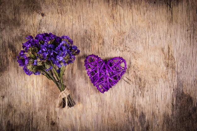 Coeur violet en osier et bouquet de fleurs séchées