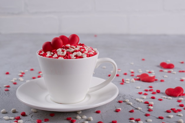 Coeurs de bonbons sucrés rouges dans une tasse de café. Décoration de concept d'amour et de la Saint-Valentin.