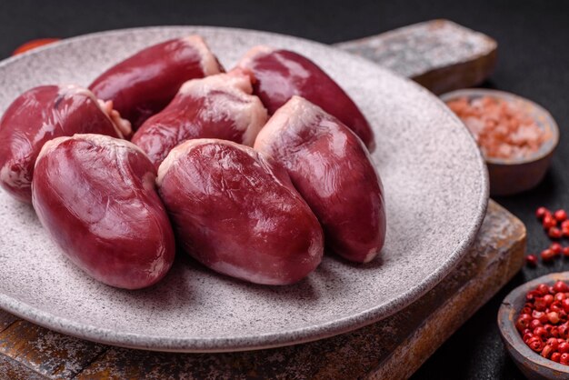 Photo cœurs de dinde ou de poulet crus avec sel et épices