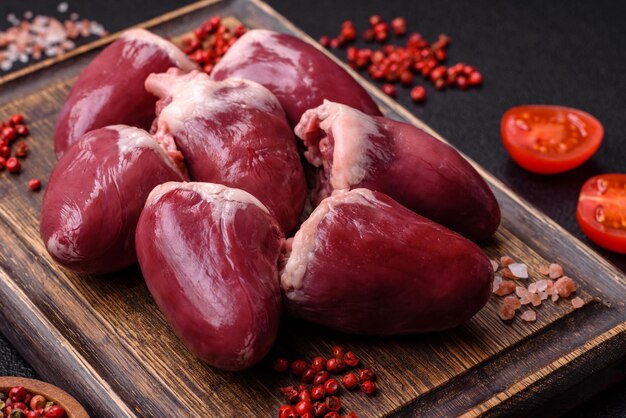 Photo cœurs de dinde ou de poulet crus avec sel et épices