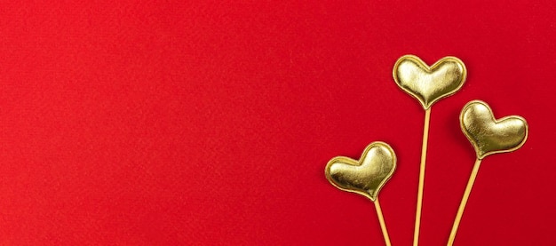 Coeurs dorés Saint Valentin sur fond rouge. 14 février, amour, concept de salutation, vue de dessus et photo de l'espace de copie