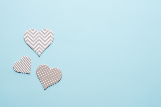 Coeurs gris avec des motifs sur fond bleu pour la Saint-Valentin