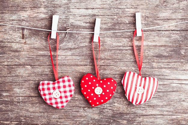 Coeurs de Noël cousus blancs et rouges attachés à la corde. Fond de vacances pour les salutations Saint Valentin