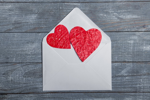 Coeurs de papier rouge avec enveloppe sur une surface en bois