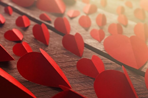 Coeurs de papier rouge sur fond de bois se bouchent