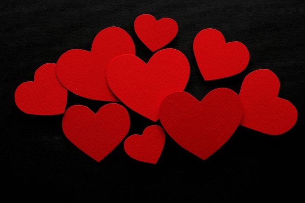 Coeurs de papier rouge sur fond noir